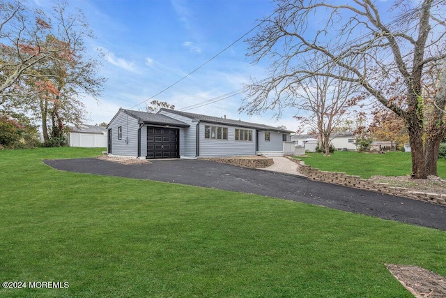 single story home featuring a garage and a front lawn