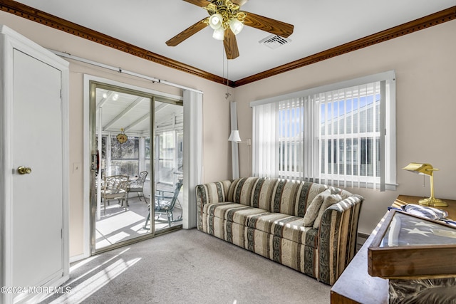 carpeted living room with ceiling fan and ornamental molding