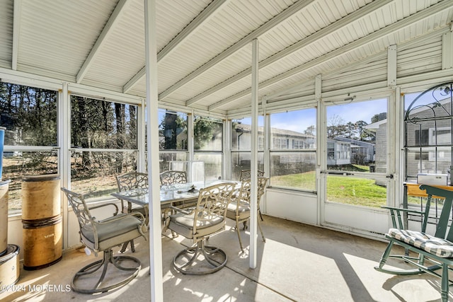 sunroom featuring vaulted ceiling with beams