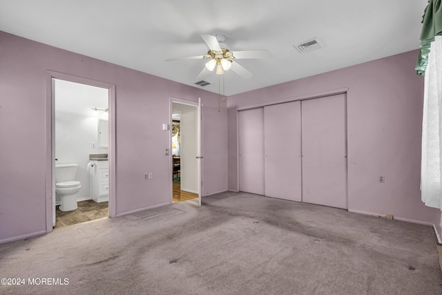 unfurnished bedroom featuring light carpet, connected bathroom, a closet, and ceiling fan