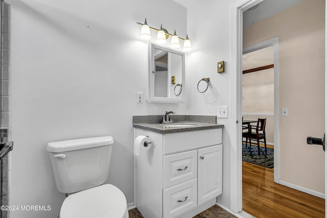 bathroom with toilet, vanity, and hardwood / wood-style flooring