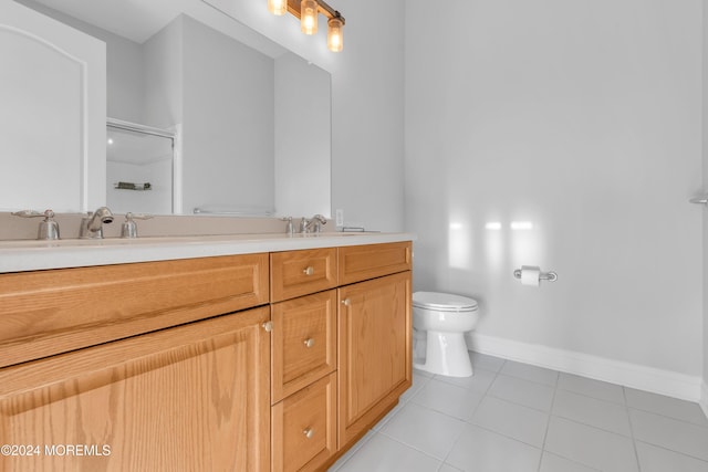 bathroom with toilet, vanity, and tile patterned floors