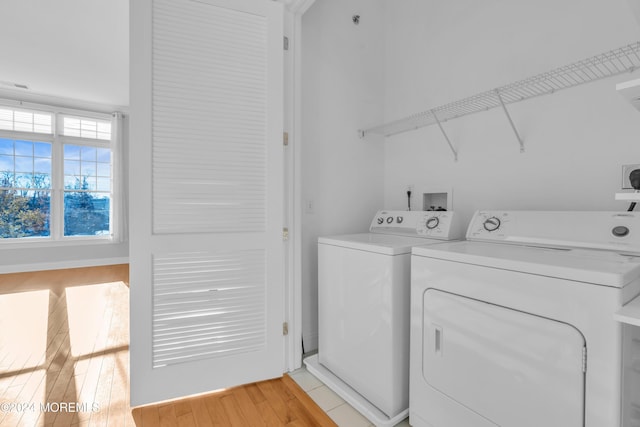 washroom with light hardwood / wood-style flooring and washing machine and clothes dryer