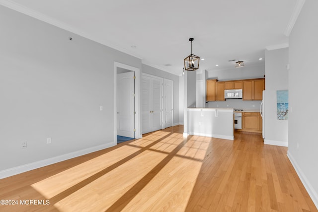 unfurnished living room featuring a notable chandelier, light wood-type flooring, and ornamental molding