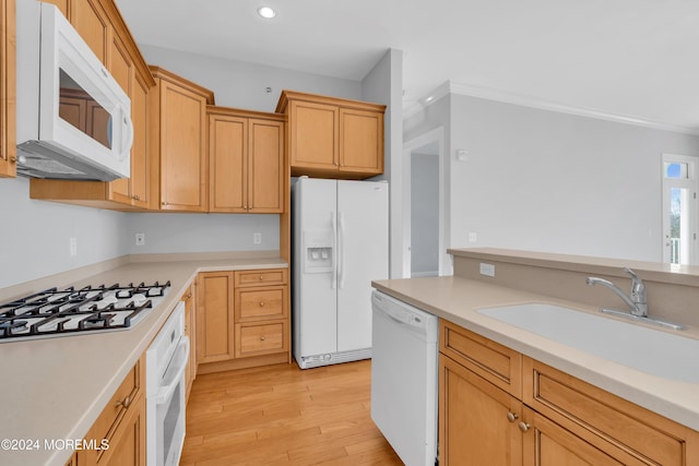 kitchen featuring white appliances, light hardwood / wood-style flooring, ornamental molding, and sink