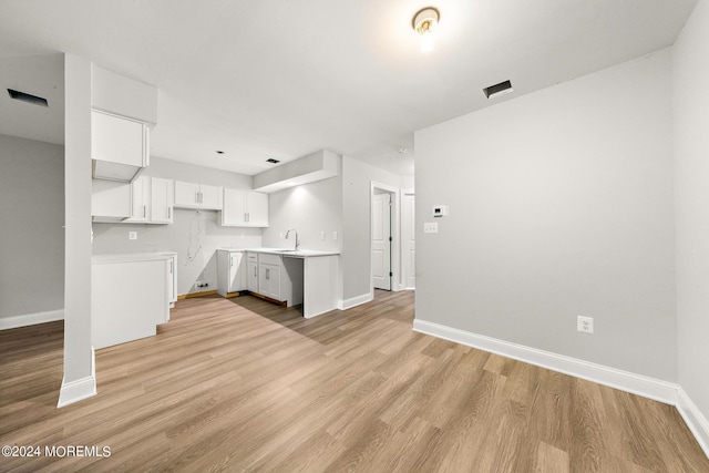 kitchen featuring light hardwood / wood-style floors, white cabinetry, and sink