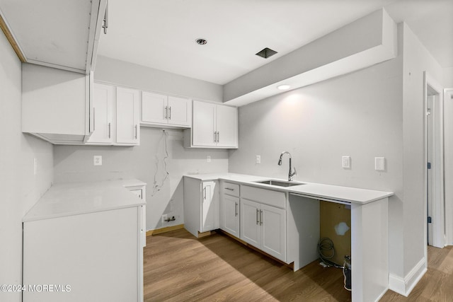 kitchen featuring white cabinets, light hardwood / wood-style floors, and sink