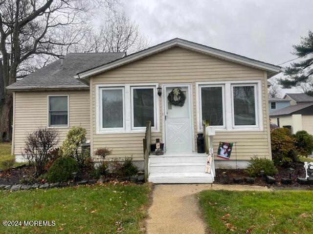 bungalow featuring a front lawn