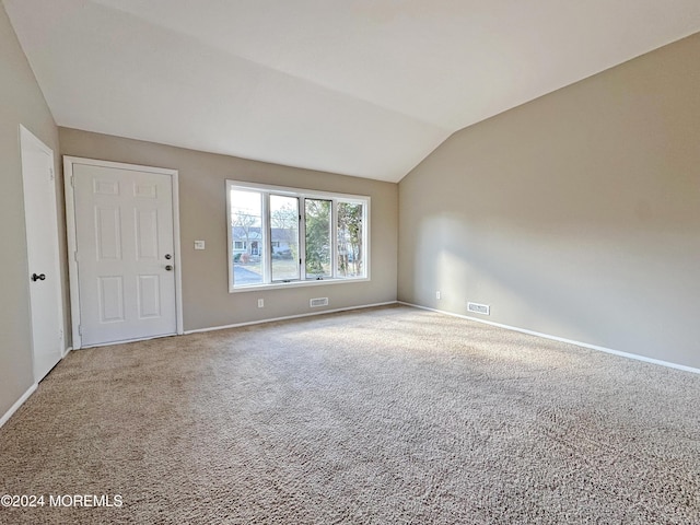 carpeted spare room featuring lofted ceiling