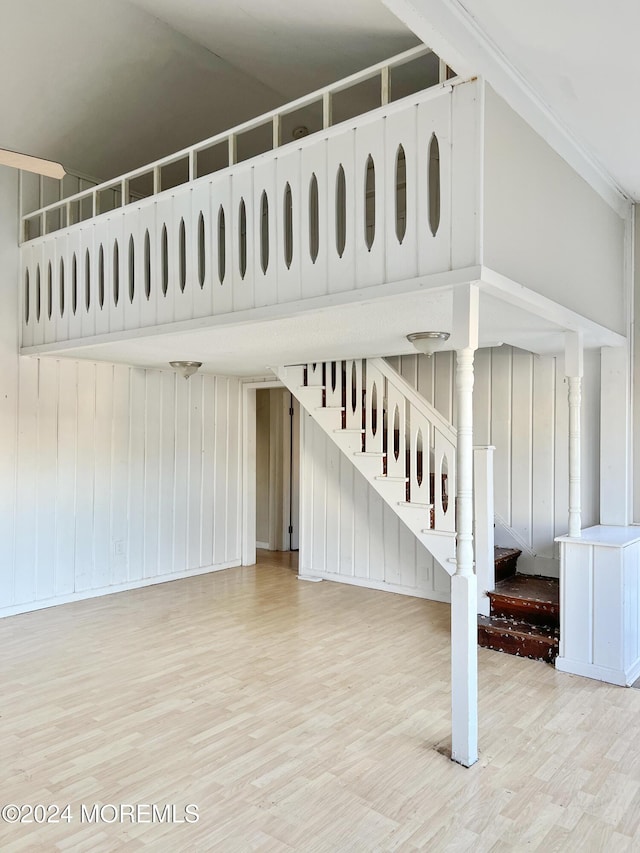 stairway with hardwood / wood-style floors and wood walls