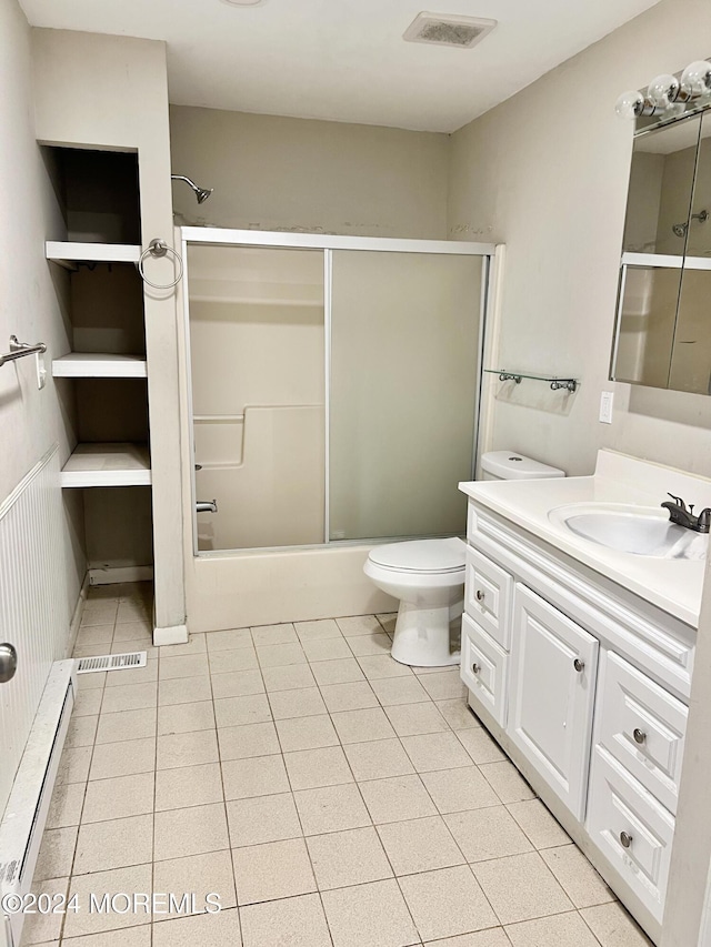 full bathroom featuring a baseboard radiator, combined bath / shower with glass door, tile patterned floors, toilet, and vanity