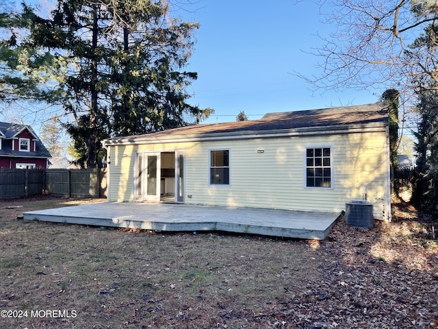 rear view of house with cooling unit and a wooden deck