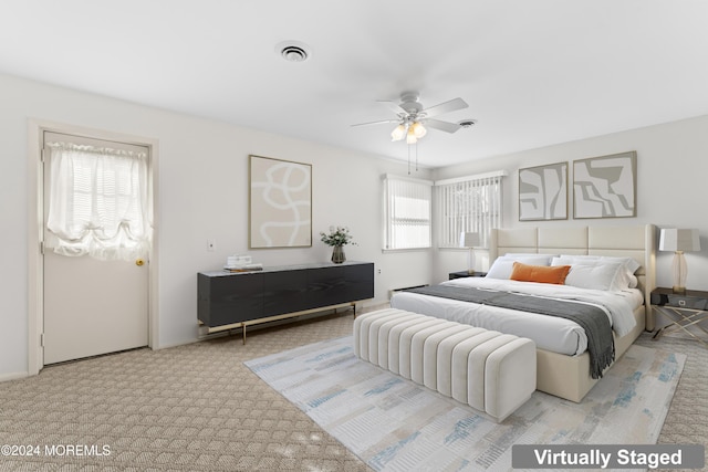 carpeted bedroom featuring multiple windows and ceiling fan