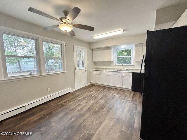 kitchen featuring black appliances, sink, hardwood / wood-style flooring, a baseboard radiator, and white cabinetry