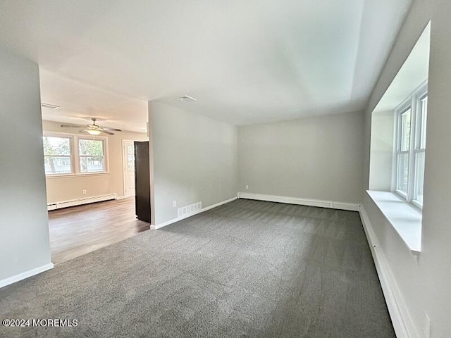 unfurnished room featuring carpet floors, ceiling fan, and a baseboard heating unit