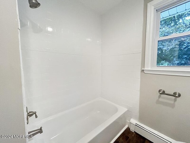 bathroom featuring shower / bathtub combination and a baseboard heating unit