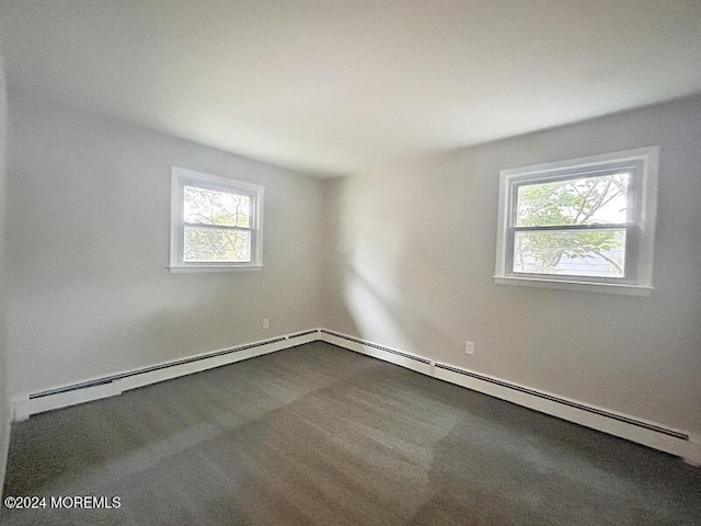 carpeted spare room with a healthy amount of sunlight and baseboard heating