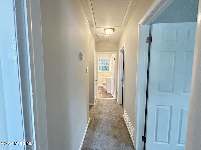 hall with dark colored carpet