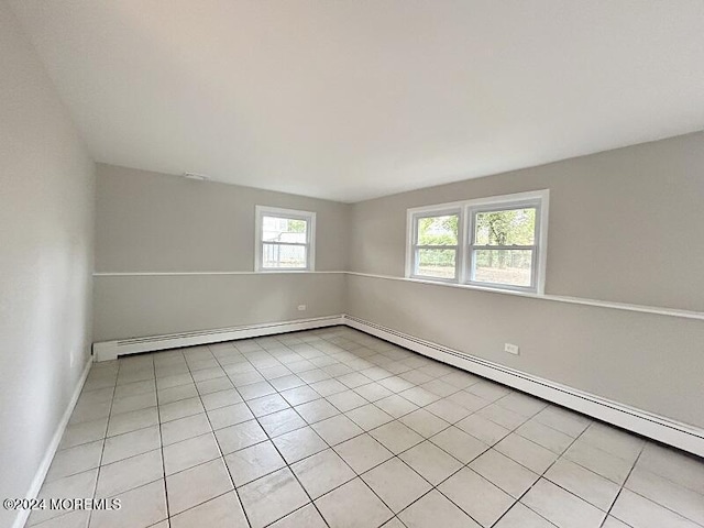 tiled spare room with a baseboard heating unit