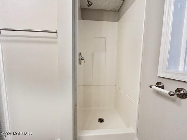 bathroom featuring a shower and a textured ceiling