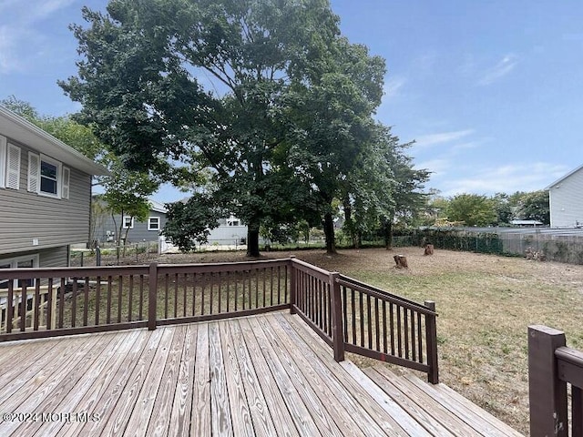 wooden terrace featuring a lawn