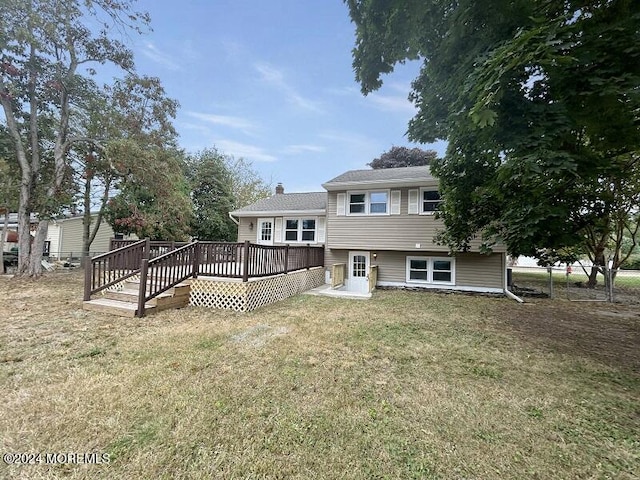 back of house with a lawn and a deck