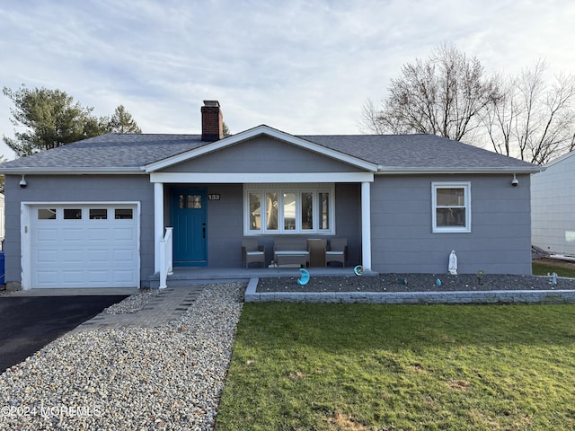 ranch-style house featuring a garage, a front lawn, and a porch