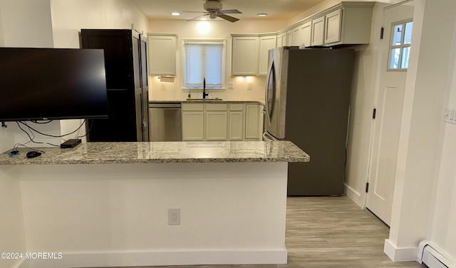 kitchen featuring baseboard heating, stainless steel appliances, light stone countertops, and kitchen peninsula