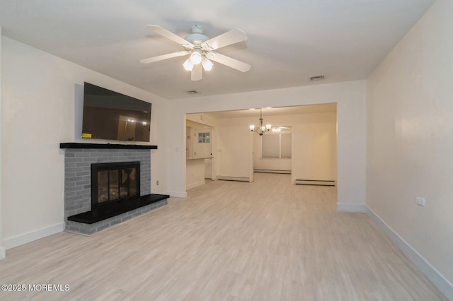 unfurnished living room featuring a baseboard heating unit, a brick fireplace, ceiling fan with notable chandelier, and light wood-type flooring