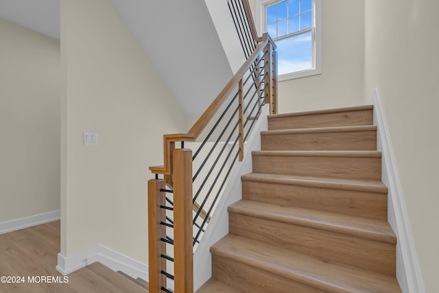 stairway with hardwood / wood-style floors