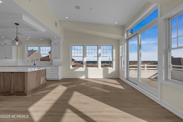 kitchen with hanging light fixtures, visible vents, baseboards, and wood finished floors