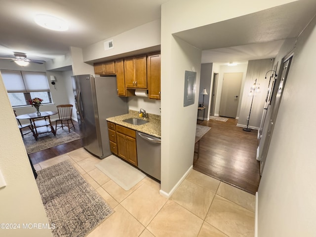 kitchen featuring ceiling fan, sink, light wood-type flooring, and stainless steel appliances