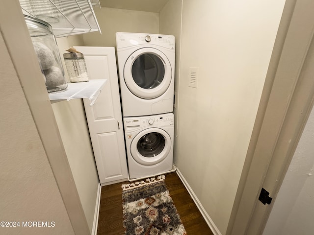 laundry room featuring dark wood-type flooring and stacked washer and clothes dryer