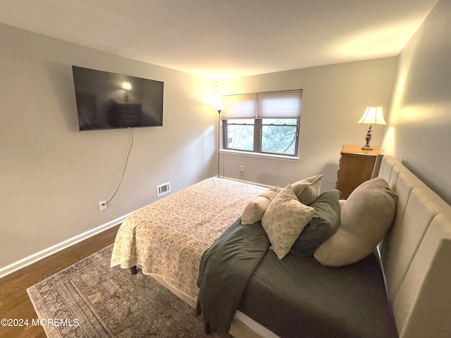 bedroom with dark hardwood / wood-style floors