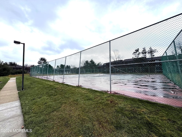 view of tennis court with a lawn