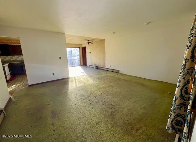 spare room featuring ceiling fan and a baseboard heating unit