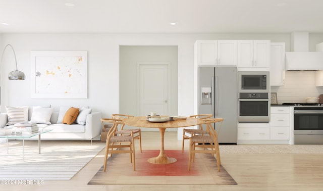 kitchen with white cabinetry, stainless steel appliances, tasteful backsplash, custom exhaust hood, and light wood-type flooring