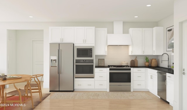 kitchen featuring premium range hood, white cabinetry, sink, and stainless steel appliances