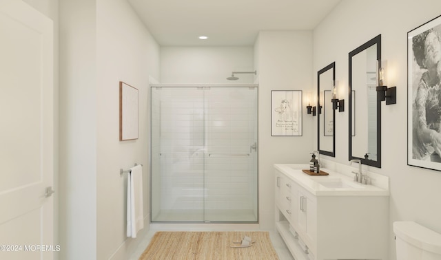 bathroom featuring vanity, toilet, and a shower with door