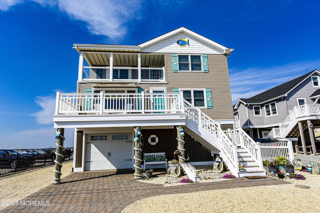 coastal home featuring a porch and a garage