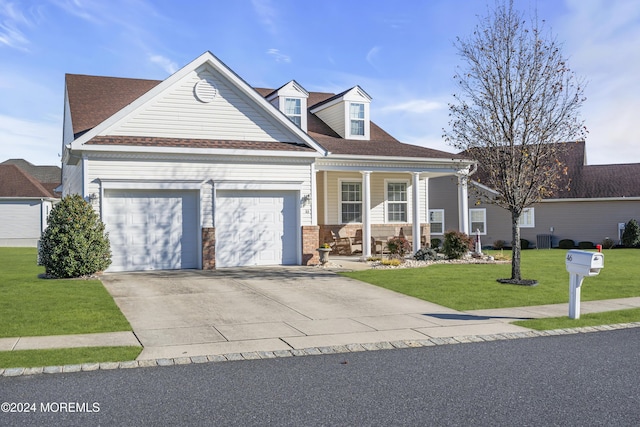 view of front of house with a porch, a garage, a front yard, and central AC