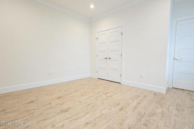 spare room featuring crown molding and light hardwood / wood-style flooring