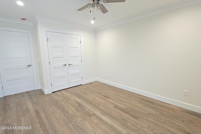 unfurnished bedroom featuring ceiling fan, a closet, ornamental molding, and light hardwood / wood-style flooring