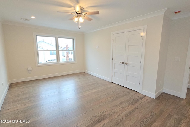 unfurnished bedroom with a closet, ceiling fan, light hardwood / wood-style flooring, and ornamental molding