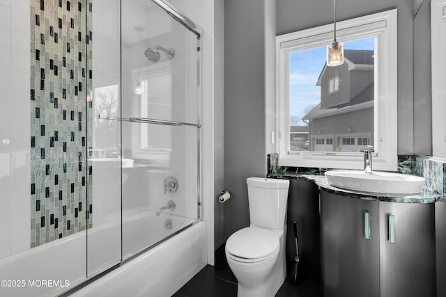 bathroom featuring vanity, toilet, and combined bath / shower with glass door