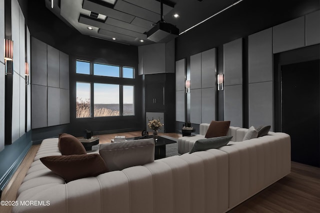 home theater room featuring recessed lighting, wood finished floors, and a towering ceiling