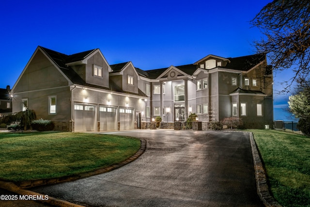 view of front of property with aphalt driveway, an attached garage, central AC, and a front lawn