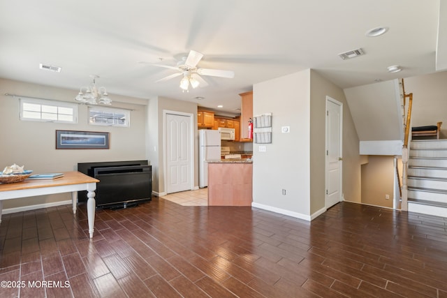 living room featuring ceiling fan with notable chandelier and dark hardwood / wood-style floors