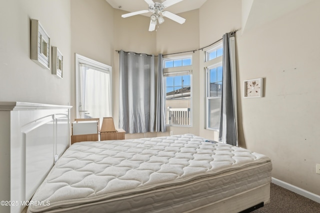 bedroom featuring ceiling fan, a towering ceiling, and carpet