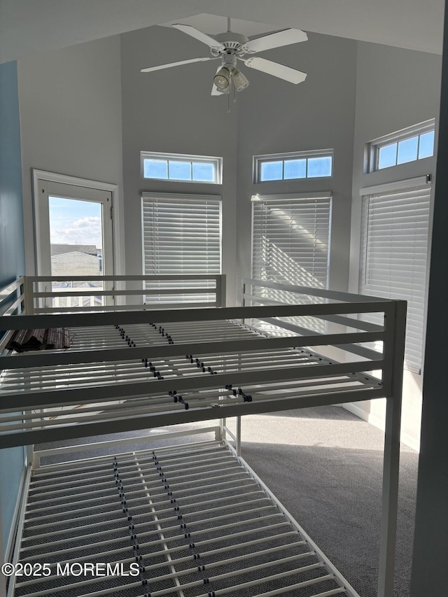 stairs with ceiling fan and a high ceiling